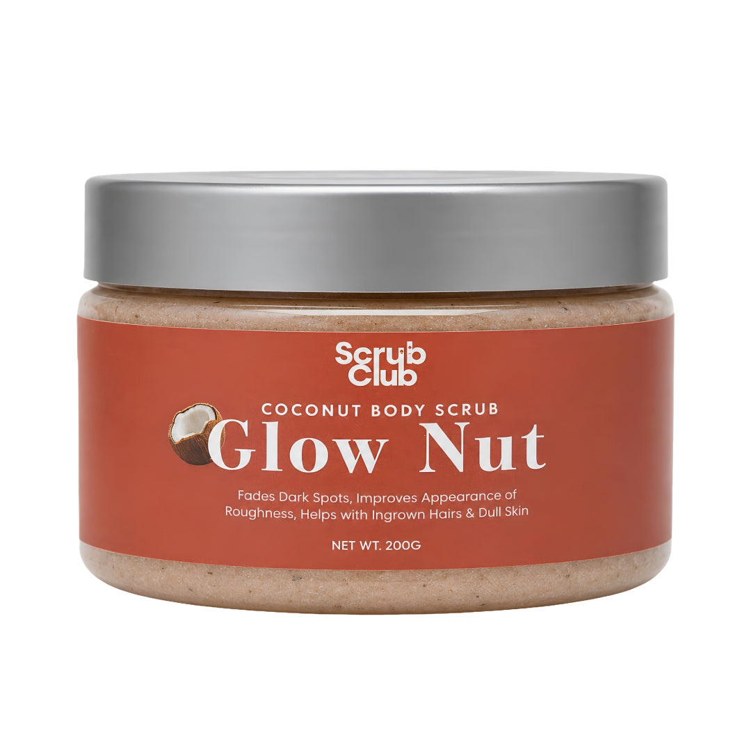 A jar of Scrub Club Coconut Body Scrub in the Glow Nut scent, featuring a terracotta-colored label and a metallic silver lid, set against a plain white background.