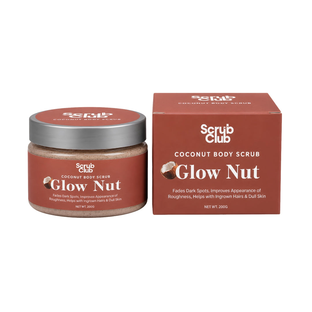 A jar of Scrub Club Coconut Body Scrub in the Glow Nut scent next to its matching brown cardboard box, shown on a plain white background.